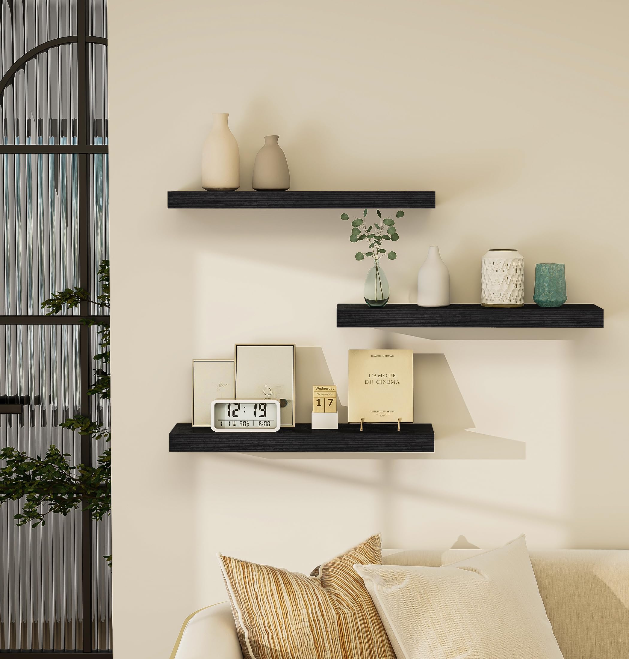 Three black Vervida floating shelves styled in a living room